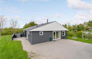 a gray house with a large patio in a yard at Cozy Home In Fars With Wifi in Hvalpsund