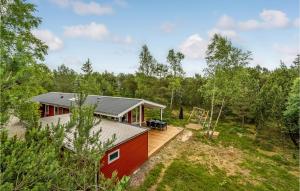 HelberskovにあるCozy Home In Hadsund With Saunaの森の中にデッキがある赤い家