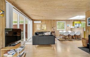 HelberskovにあるNice Home In Hadsund With 3 Bedrooms, Sauna And Wifiのリビングルーム(ソファ、テーブル付)
