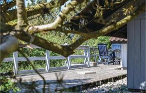 a wooden deck with chairs and a table at Holiday Home Tranevej Xii in Ebeltoft