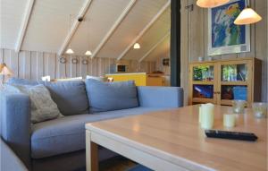 エーベルトフトにあるAmazing Home In Ebeltoft With 3 Bedroomsのリビングルーム(青いソファ、テーブル付)