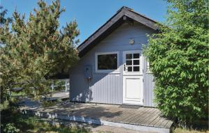 エーベルトフトにあるAmazing Home In Ebeltoft With 3 Bedroomsの白い扉付きの小さな青い小屋