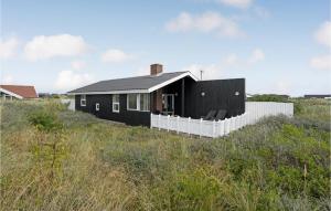 a black house on a hill in a field at 5 Bedroom Cozy Home In Hvide Sande in Havrvig