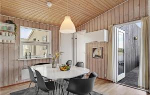 a dining room with a table and chairs at 5 Bedroom Cozy Home In Hvide Sande in Havrvig