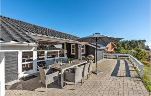a patio with a table and an umbrella at 4 Bedroom Lovely Home In Rm in Rømø Kirkeby