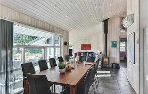 uma sala de jantar com uma longa mesa de madeira e cadeiras em 4 Bedroom Lovely Home In Rm em Rømø Kirkeby