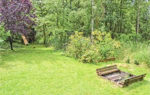 a wooden bench sitting in the grass in a yard at Two-Bedroom Holiday Home In Frederiksvark in Frederiksværk