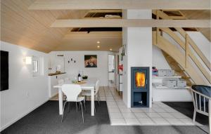 a kitchen and dining room with a table and a fireplace at Four-Bedroom Holiday Home In Norre Nebel in Nørre Nebel