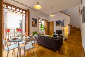 a living room with a couch and a table at La Casa del Conde de Gelves Apartments in Seville