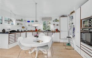 Una cocina blanca con una mesa y sillas blancas. en 2 Bedroom Nice Home In Askeby, en Askeby