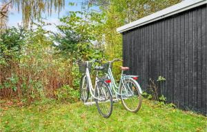 dos bicicletas están estacionadas al lado de un edificio negro en Beautiful Home In Askeby With Kitchen en Askeby