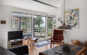 un soggiorno con televisione, tavolo e sedie di Holiday Home Fiskervej Ebeltoft Xi a Ebeltoft