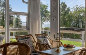 una stanza con un tavolo, sedie e finestre di Holiday Home Fiskervej Ebeltoft Xi a Ebeltoft