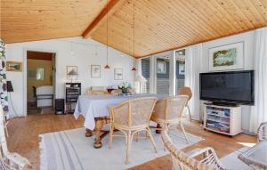 una sala da pranzo con un tavolo e una tv di Holiday Home Fiskervej Ebeltoft Xi a Ebeltoft