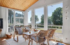una stanza con un tavolo, sedie e finestre di Holiday Home Fiskervej Ebeltoft Xi a Ebeltoft