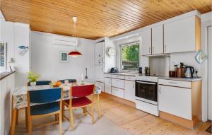 エーベルトフトにあるAmazing Home In Ebeltoft With Wifiの白いキャビネットと木製の天井が備わるキッチン