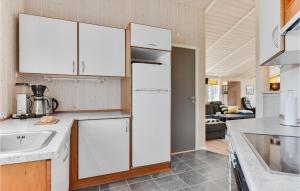 a kitchen with white cabinets and a sink at Awesome Home In Juelsminde With Sauna in Sønderby