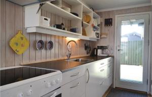 Bjerregårdにある2 Bedroom Amazing Home In Hvide Sandeの白いキャビネット、シンク、窓付きのキッチン