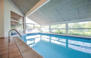 a swimming pool in a house with a large window at Stunning Home In Ebeltoft With Kitchen in Ebeltoft