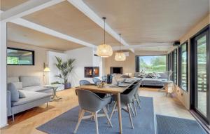 a dining room and living room with a table and chairs at Amazing Home In Knebel With 3 Bedrooms, Wifi And Indoor Swimming Pool in Skødshoved Strand