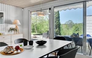 una cucina e una sala da pranzo con tavolo e sedie di Nice Home In Ebeltoft With Sauna a Ebeltoft
