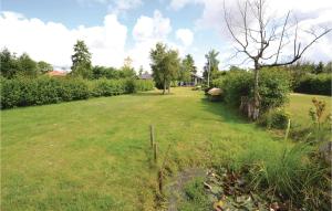 a field of grass with a fence and a tree at Holiday Home Silkeborg 8 in Silkeborg