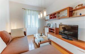 ein Wohnzimmer mit einem Sofa und einem Flachbild-TV in der Unterkunft Nice Home In Dragozetici With House Sea View in Dragozetići