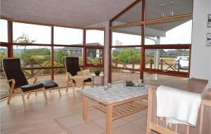 - un salon avec une table, des chaises et des fenêtres dans l'établissement Cozy Home In Tarm With Sauna, à Tarm