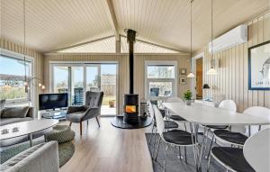 SpodsbjergにあるGorgeous Home In Rudkbing With Wifiのリビングルーム(テーブル、椅子、暖炉付)