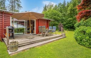 une terrasse en bois avec une table et un parasol dans l'établissement Cozy Home In Mern With Wifi, à Mern