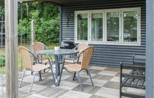 - une table et des chaises sur une terrasse avec barbecue dans l'établissement Two-Bedroom Holiday Home In Storvorde, à Storvorde