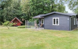 un hangar bleu avec une table dans une cour dans l'établissement Two-Bedroom Holiday Home In Storvorde, à Storvorde
