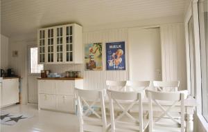 a kitchen with white chairs and a table at Four-Bedroom Holiday Home In Hornbak in Hornbæk