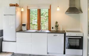 une cuisine avec des armoires blanches et une fenêtre dans l'établissement Two-Bedroom Holiday Home In Storvorde, à Storvorde 3 autres photos