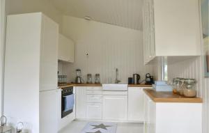 a white kitchen with white cabinets and appliances at Four-Bedroom Holiday Home In Hornbak in Hornbæk