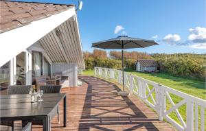 a deck with a table and an umbrella at 3 Bedroom Beautiful Home In Rm in Bolilmark