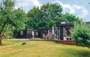 a black tiny house sitting in a yard at Awesome Home In lsted With 3 Bedrooms And Wifi in Ølsted