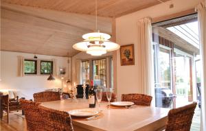 un comedor con una mesa con botellas de vino. en Lovely Home In Gilleleje With Kitchen, en Gilleleje