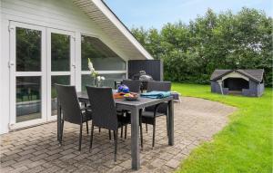 un patio con tavolo, sedie e griglia di Beautiful Home In Sydals With Sauna a Neder Lysabild Altre 23 foto