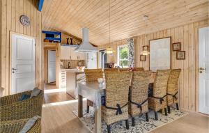 een keuken en eetkamer met een tafel en stoelen bij Amazing Home In Grenaa With Sauna in Stokkebro