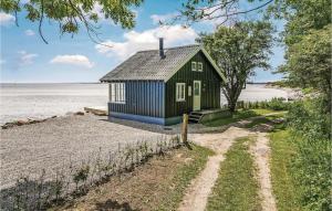 a small house on the shore of a body of water at Awesome Home In Broager With 2 Bedrooms And Wifi in Skelde