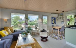 Beautiful Home In Haarby With Kitchen في Brunshuse: غرفة معيشة مع أريكة زرقاء وطاولة