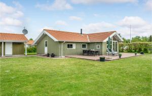 ein grünes Haus mit Rasen davor in der Unterkunft 4 Bedroom Nice Home In Sklskr in Skælskør
