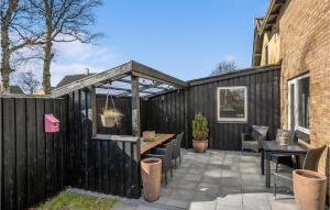 a patio with a black fence and a table and chairs at 3 Bedroom Stunning Home In Ålbæk in Ålbæk +17 photos
