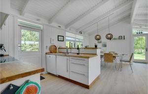 Una cocina con gabinetes blancos y una mesa de comedor. en Lovely Home In Jerup With Kitchen, en Jerup