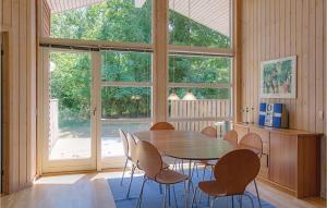 HasleにあるRubinsen Skovhuseのダイニングルーム(テーブル、椅子付)、大きな窓が備わります。