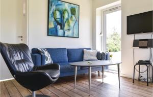 a living room with a blue couch and a table at Beautiful Home In Ringkbing With Wifi in Hee