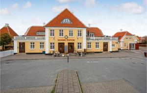 un gran edificio amarillo con techo rojo en 3 Bedroom Beautiful Home In Skagen, en Skagen
