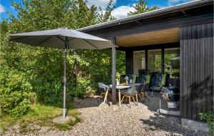 een patio met een tafel met een parasol en een grill bij Beautiful Home In Grsted With Wifi in Græsted