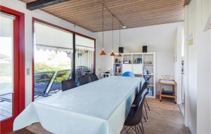 Nice Home In Assens With House Sea View في أسّينس: غرفة طعام مع طاولة بيضاء كبيرة وكراسي